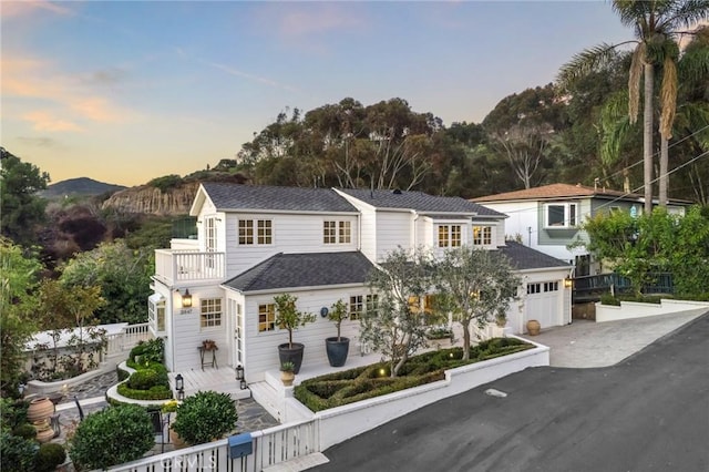 view of front property featuring a garage and a balcony