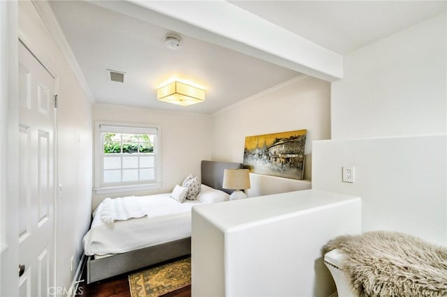 bedroom featuring ornamental molding and dark hardwood / wood-style flooring