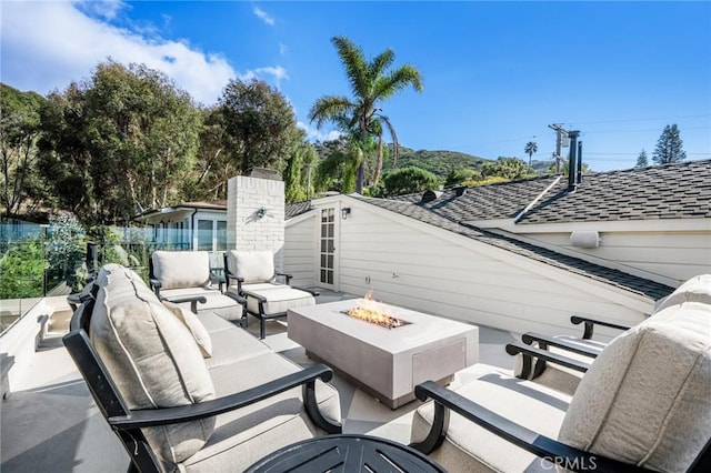 view of patio with an outdoor living space with a fire pit