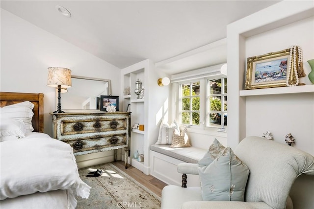 bedroom with vaulted ceiling and light wood-type flooring