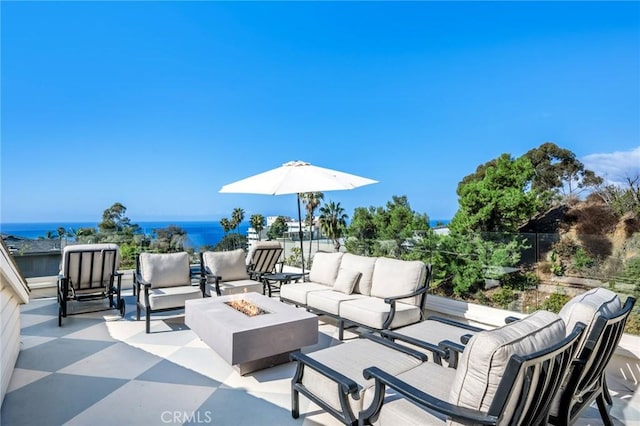 view of patio / terrace featuring a water view and an outdoor living space with a fire pit