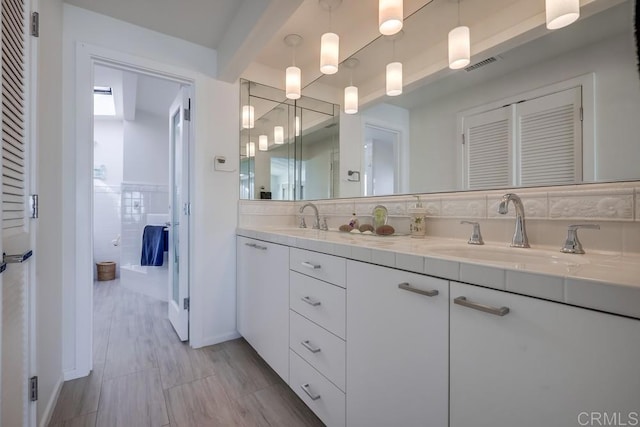 bathroom featuring vanity, beam ceiling, and tile walls