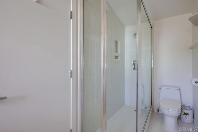 bathroom featuring an enclosed shower, tile patterned floors, and toilet