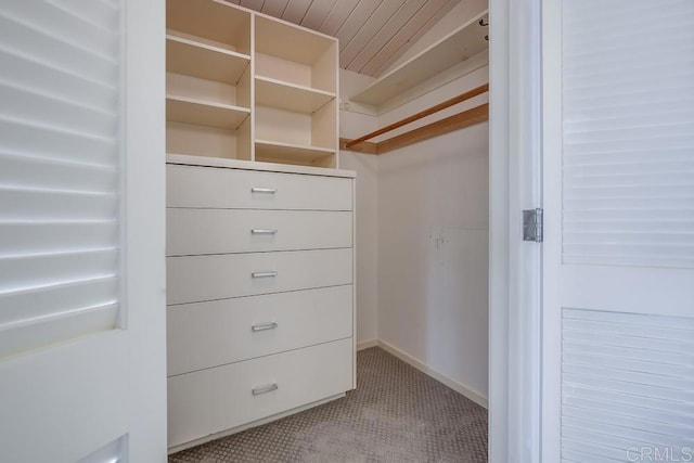 walk in closet featuring light carpet