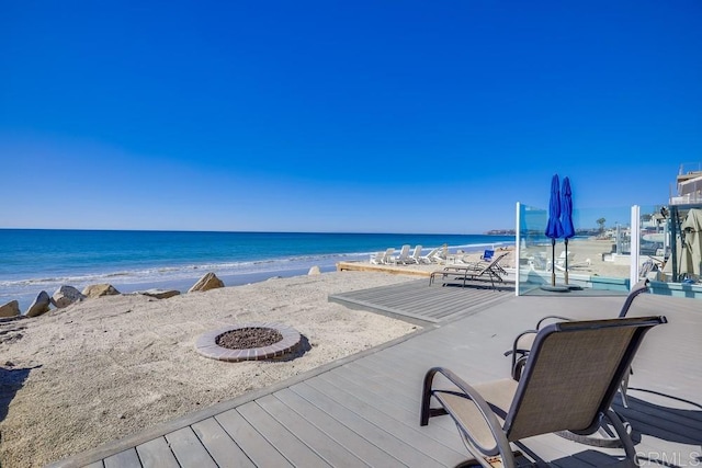 exterior space with a fire pit and a beach view