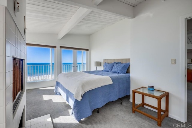 bedroom featuring access to exterior, carpet floors, vaulted ceiling with beams, and a water view