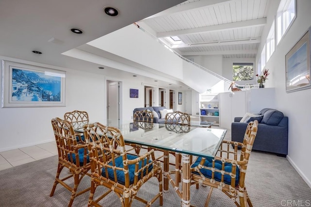 carpeted dining area featuring beamed ceiling