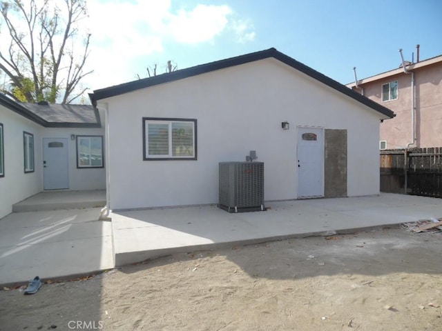 rear view of house featuring a patio and central AC