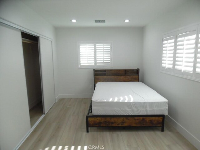 bedroom featuring light hardwood / wood-style flooring and a closet