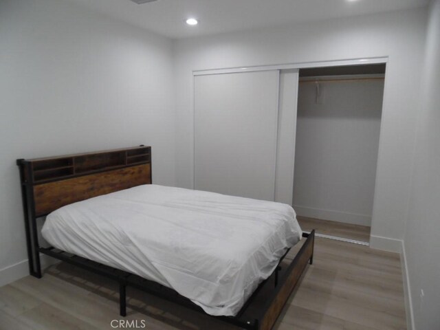 bedroom featuring wood-type flooring and a closet