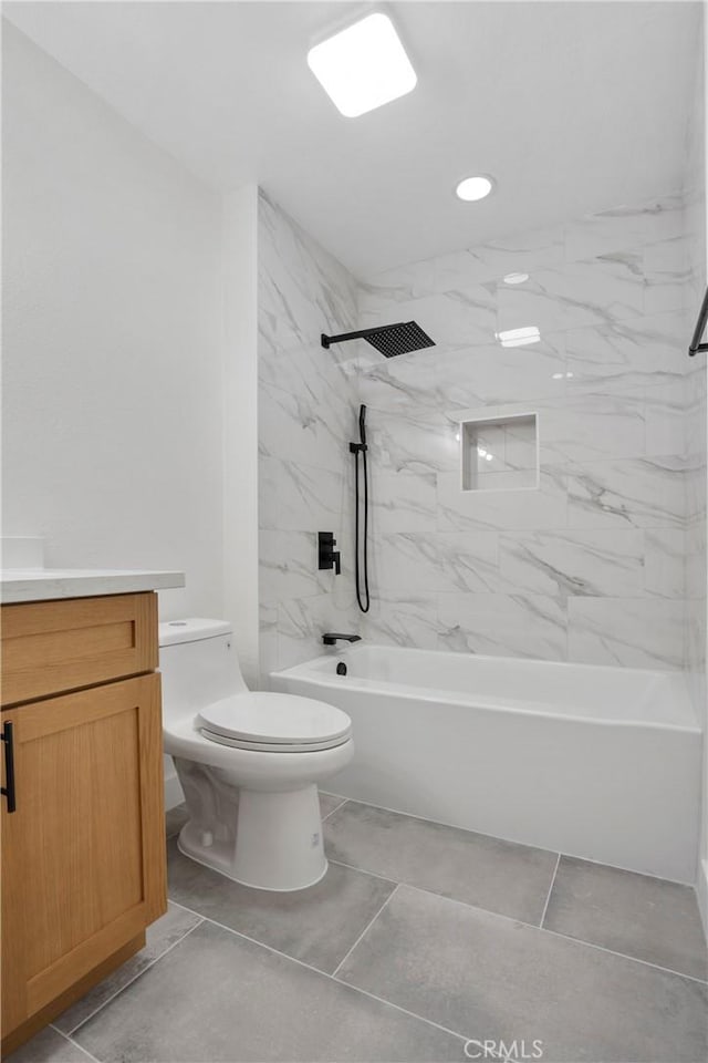 full bathroom featuring vanity, tiled shower / bath combo, tile patterned floors, and toilet