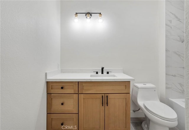 bathroom with vanity, a tub to relax in, and toilet