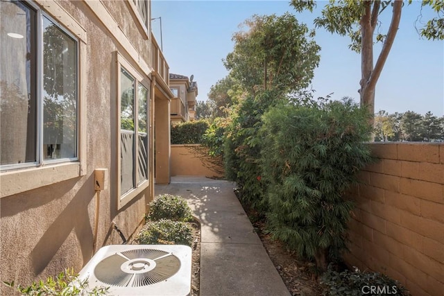 view of side of property featuring central AC unit and a patio area