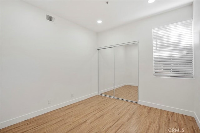 unfurnished bedroom with light hardwood / wood-style floors and a closet