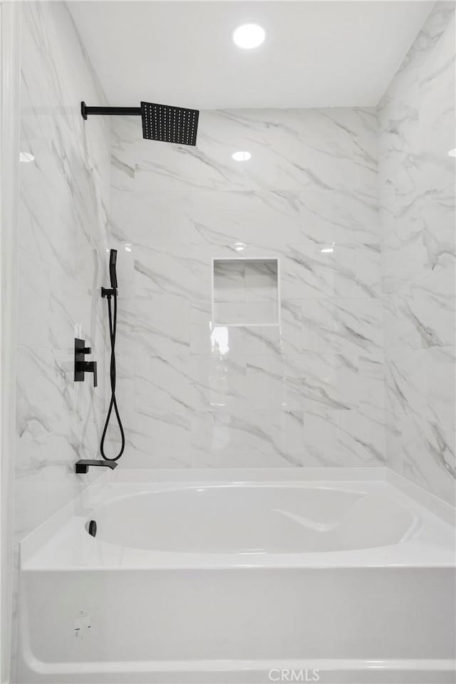 bathroom with tiled shower / bath combo