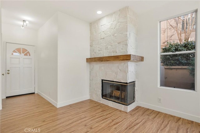 entryway with a fireplace and light hardwood / wood-style floors