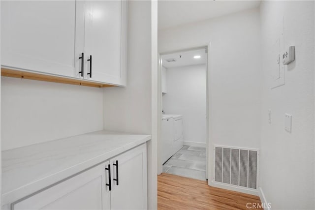 interior space with washing machine and clothes dryer and light wood-type flooring