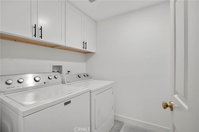 clothes washing area featuring cabinets and washing machine and dryer