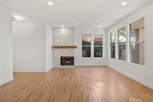 unfurnished living room with a fireplace and light hardwood / wood-style flooring