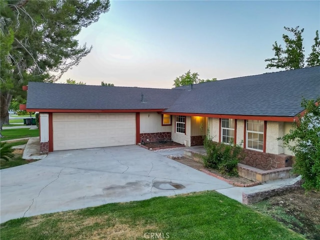 single story home featuring stone siding, concrete driveway, roof with shingles, and an attached garage