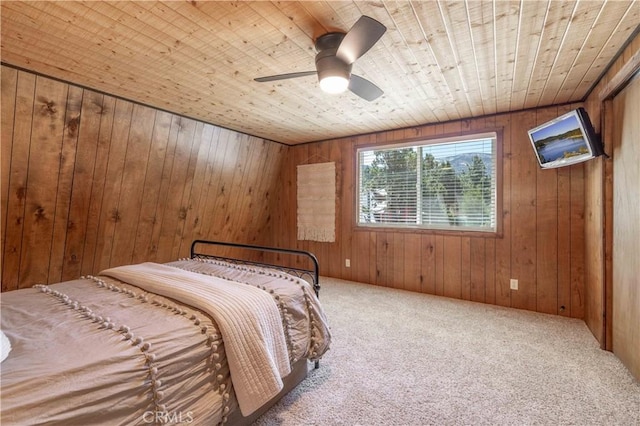 unfurnished bedroom with wood ceiling, carpet floors, ceiling fan, and wood walls