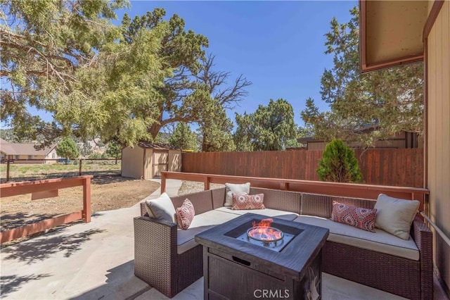 view of patio with an outdoor living space with a fire pit