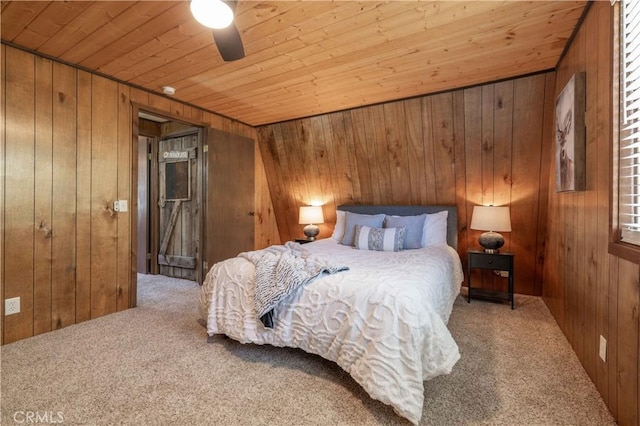 carpeted bedroom with wood ceiling, ceiling fan, and wood walls