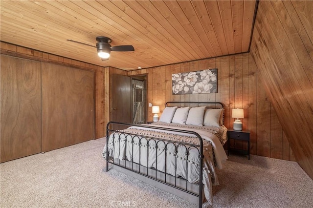 bedroom featuring wood ceiling, ceiling fan, wooden walls, and carpet flooring