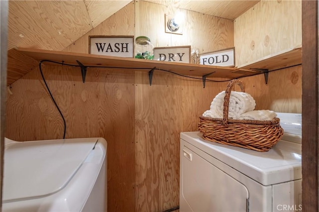 laundry room with independent washer and dryer and wooden walls