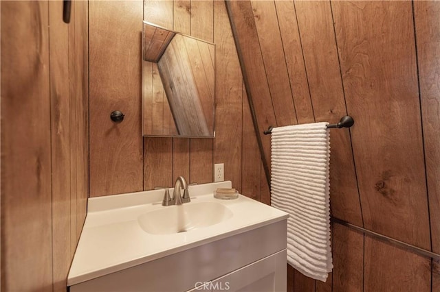 bathroom with vanity and wooden walls