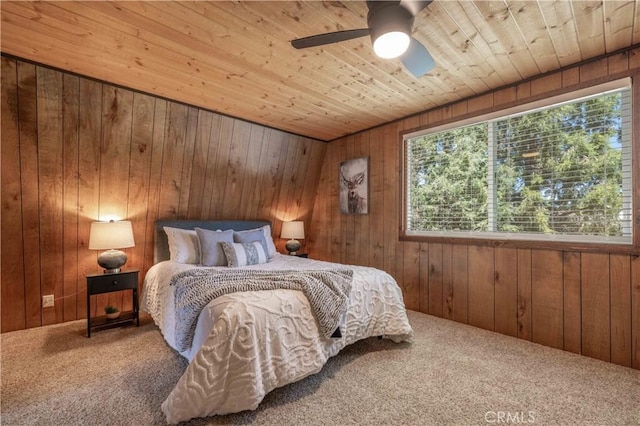 bedroom with ceiling fan and wood walls