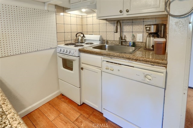 kitchen featuring sink, white appliances, light wood-type flooring, and backsplash