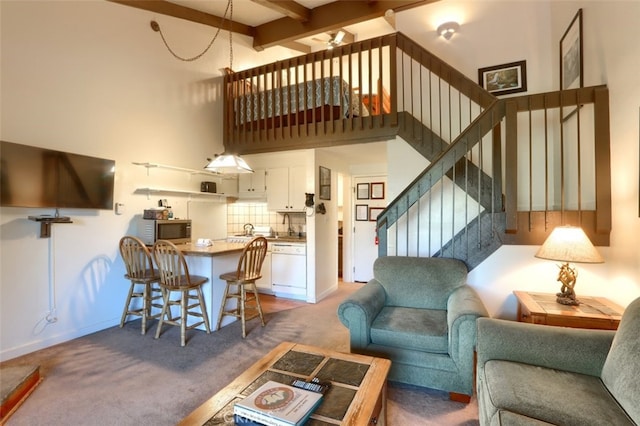 living room with beamed ceiling, ceiling fan, and carpet flooring