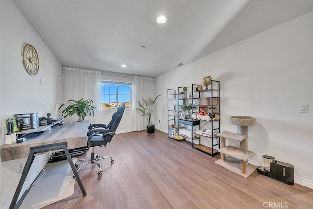 home office with light hardwood / wood-style flooring