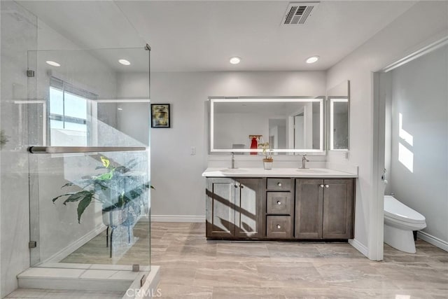 bathroom featuring vanity, toilet, and a shower with shower door