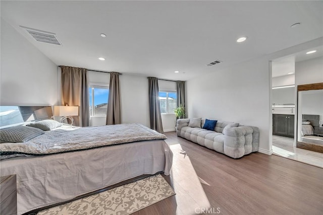 bedroom featuring ensuite bath and wood-type flooring