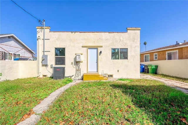 back of property with a yard and central air condition unit