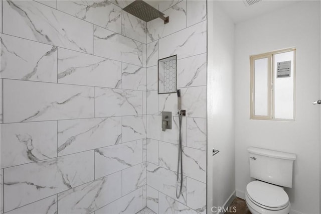 bathroom with toilet and tiled shower