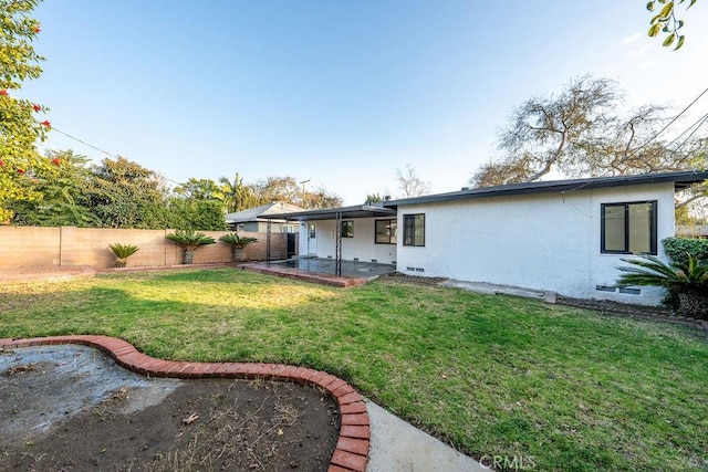 back of house featuring a patio and a lawn