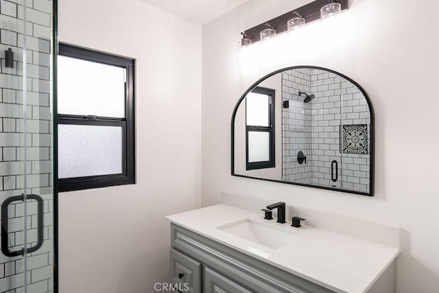 bathroom with vanity and a shower with door