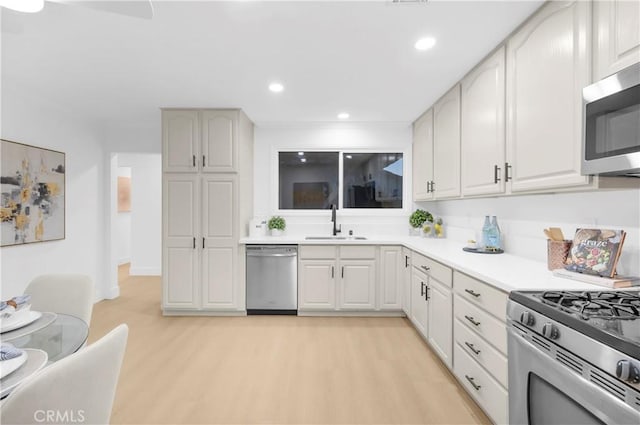 kitchen featuring white cabinetry, stainless steel appliances, light hardwood / wood-style floors, and sink