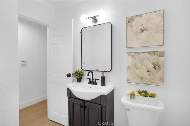 bathroom featuring crown molding, vanity, toilet, and hardwood / wood-style floors