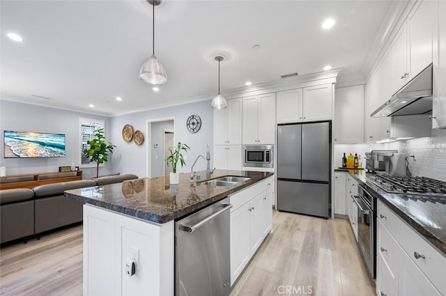 kitchen with pendant lighting, sink, stainless steel appliances, an island with sink, and white cabinets