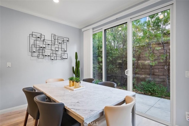 dining room featuring crown molding and light hardwood / wood-style floors