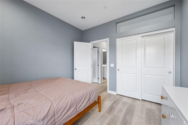 bedroom with light hardwood / wood-style flooring and a closet