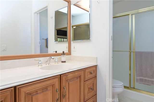 bathroom with tile patterned floors, vanity, toilet, and an enclosed shower