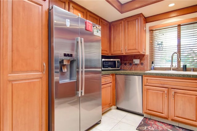 kitchen featuring tasteful backsplash, stainless steel appliances, sink, and light tile patterned floors