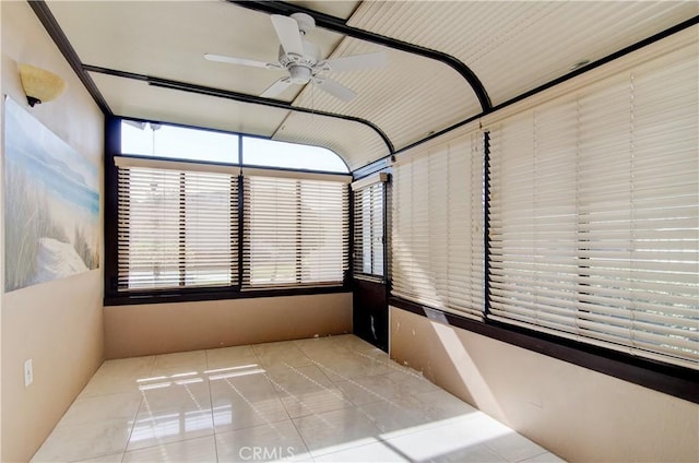 unfurnished sunroom featuring ceiling fan