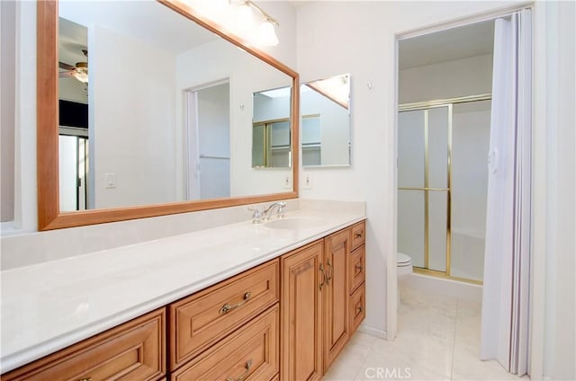 bathroom featuring toilet, a ceiling fan, a shower stall, vanity, and tile patterned floors