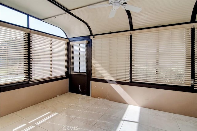 unfurnished sunroom with a ceiling fan and a wealth of natural light